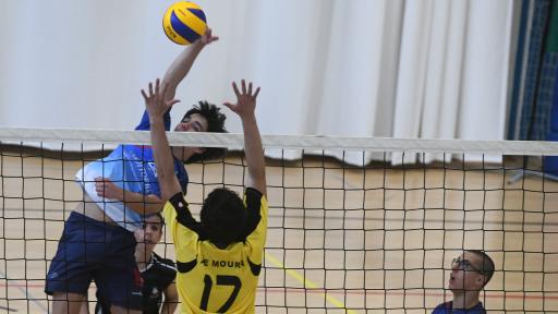 Jogador a rematar a bola acima da rede