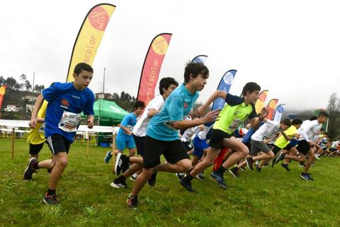 Partida com alunos a correrem. Por detrás as bandeiras do desporto Escolar