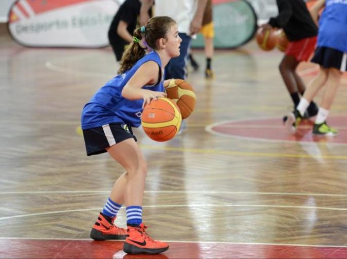 Aluna a driblar duas bolas de basquetebol